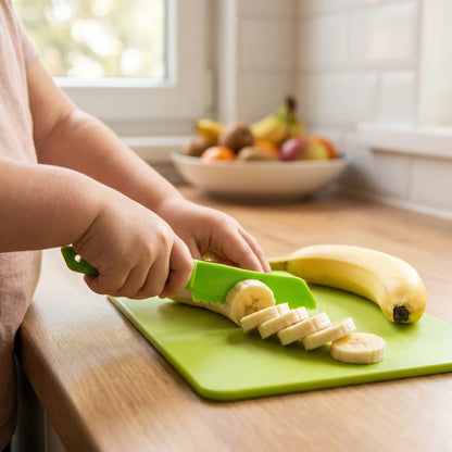 Kind schneidet sicher eine Banane mit dem grünen MiniKochBar Kunststoffmesser